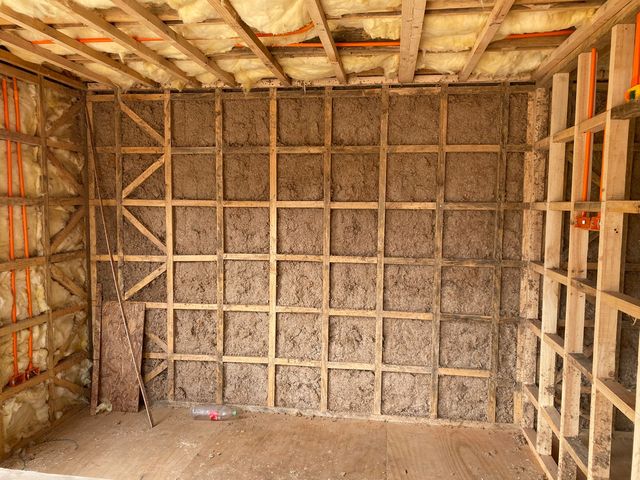 Muro con celulosa proyectada, rellenando cada espacio entre los pies derechos